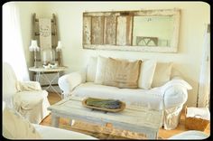 a living room filled with white furniture and pillows