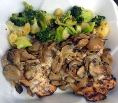 a white plate topped with chicken, mushrooms and broccoli