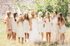 a group of women standing next to each other in front of some grass and trees