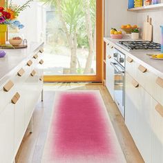 a pink rug in the middle of a kitchen