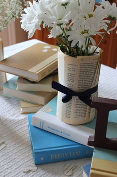 flowers in a vase sitting on top of books