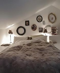 a bedroom with white walls and pictures on the wall