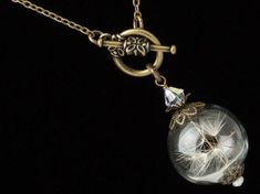 "Wish Necklace, Dandelion Necklace made with a Hand Blown Glass Orb filled with Real Dandelion Seeds accented by Genuine Pearl, Swarovski Crystal and Brass Filigree, Terrarium Necklace, Dandelion Jewelry. - Earrings Sold Separately - Hold your wishes close to your heart with this stunning handmade keepsake necklace. This exquisite hand blown glass orb terrarium has been delicately filled with little \"wishes\" and capped in gold floral filigree to keep the real dandelion seeds securely inside. A Vintage Handmade Lariat Necklace Gift, Handmade Vintage Lariat Necklace As Gift, Wish Necklace, Steampunk Bracelet, Dandelion Necklace, Steampunk Rings, Dandelion Seeds, Floral Filigree, Steampunk Earrings