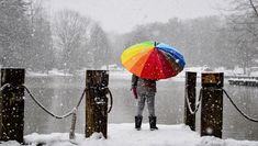 a person with an umbrella standing in the snow