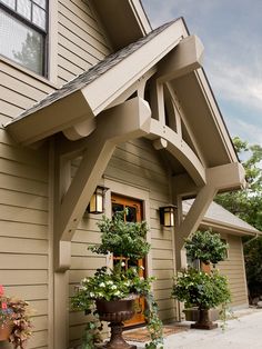 an outside view of a house with potted plants on the front and side of it