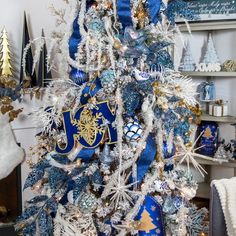 a blue and white christmas tree decorated with snowflakes, ornaments, and ribbons