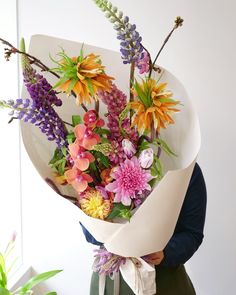 a woman holding a bouquet of flowers in her hands