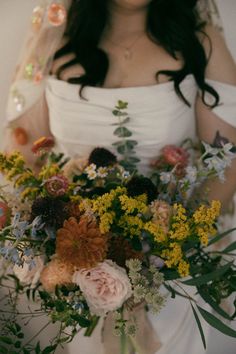 a bride holding a bouquet of flowers in her hands