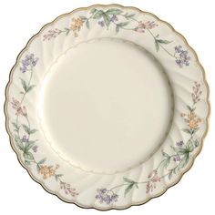 a white plate with flowers on it and gold trimming around the edge, against a white background