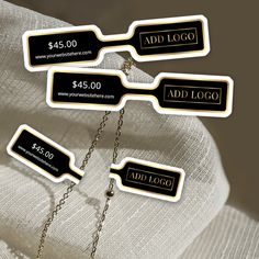 three black and white tags with chains attached to them