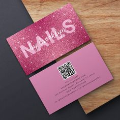 a pink business card sitting on top of a wooden table