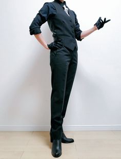 a woman dressed in black is posing for the camera with her hands on her hips