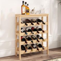 a wooden wine rack filled with lots of bottles on top of a floor next to a wall