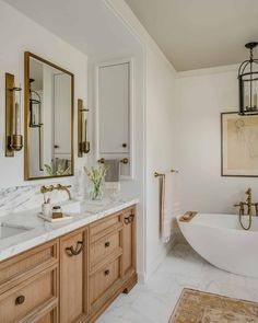 a bathroom with two sinks, a bathtub and a large mirror on the wall