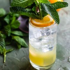 a glass filled with lemonade and mint garnish on top of a table