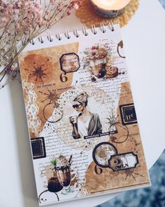 a notebook with an image of a woman on it next to a candle and flowers