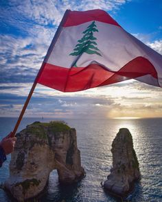 a person holding a flag near the ocean