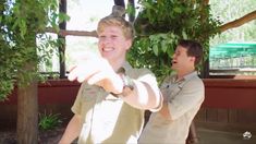 two young men pointing at something in the air