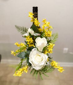 a vase filled with yellow and white flowers