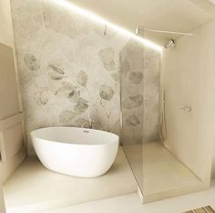 a white bath tub sitting inside of a bathroom next to a walk in shower stall