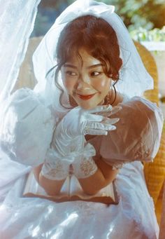 a woman in a white wedding dress and gloves