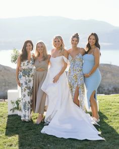 the bridesmaids are all dressed in different styles and colors, posing for a photo