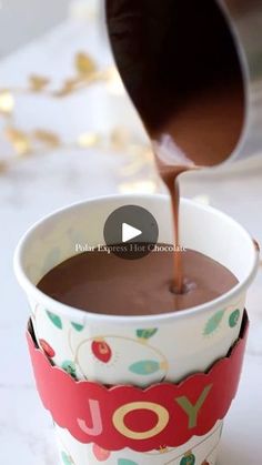 chocolate being poured into a cup with the word joy on it