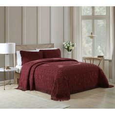 a bed in a room with a red comforter