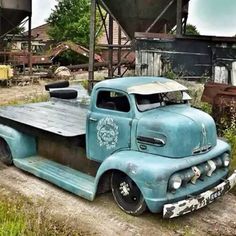 an old blue truck parked in front of a building