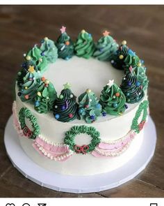 a white cake decorated with christmas trees on top