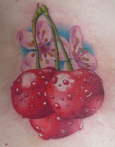 a woman's back with some flowers and cherries on it