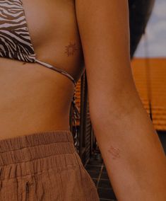 a close up of a woman's stomach with tattoos on her arm and chest