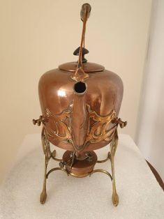 an ornately designed copper colored vase on display