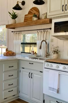 a kitchen with white cabinets and wooden counter tops