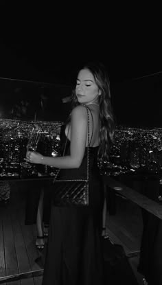 a woman standing on top of a building at night