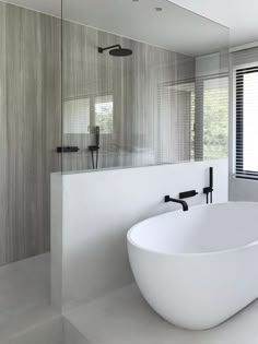 a large white bath tub sitting next to a window