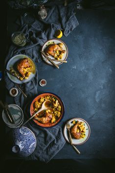 two plates filled with food sitting on top of a blue table cloth next to silverware