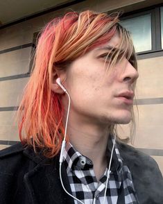 a young man with red hair wearing earphones