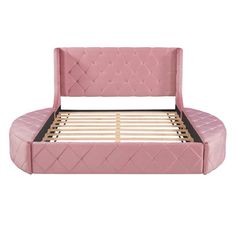 a pink bed frame with wooden slats and foot board in the shape of a couch