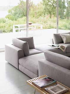 a living room filled with furniture and large windows