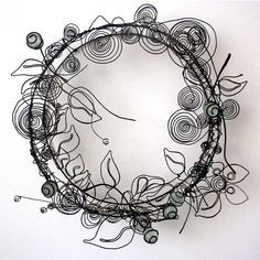 a circular sculpture made out of wire and beads