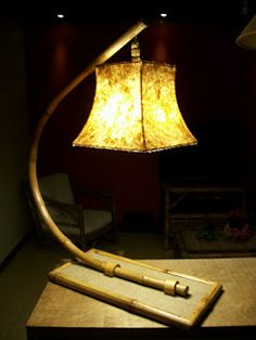 a lamp sitting on top of a wooden table next to a light fixture and chair