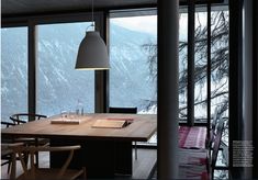 an open book with a table and chairs in front of a window overlooking the mountains