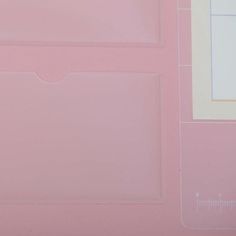 a piece of pink paper with white lines on it and a ruler next to it