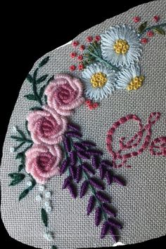 a close up of a piece of cloth with flowers on it and the word love written in cursive writing