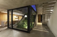 the inside of a house with glass walls and stairs leading up to an open floor plan