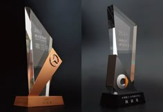 two awards are shown side by side on a black surface