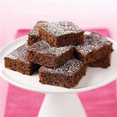 a white plate topped with brownies on top of a pink and white table cloth