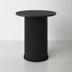 a black round table sitting on top of a white floor