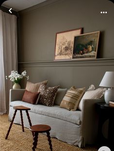 a living room filled with furniture and pictures on the wall